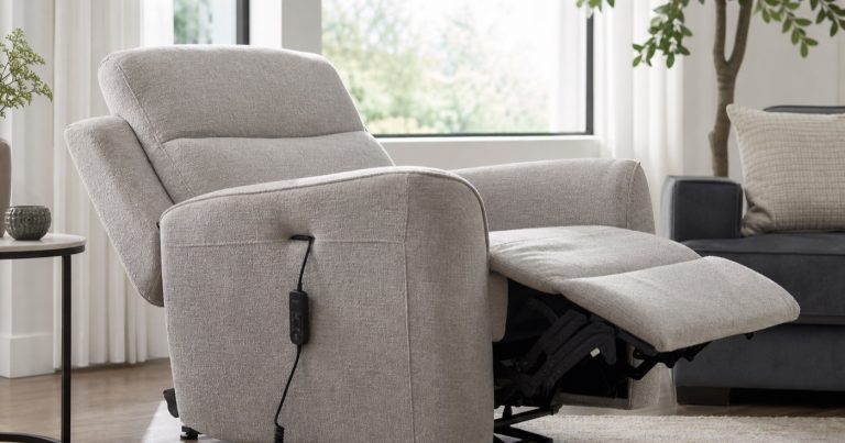 Electric reclining armchair in a modern living room with a partially extended footrest, side-mounted wired controller, upholstered seat, and visible reclining mechanism
